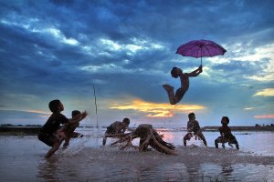 Children play in the water after school in Cooch Behar, India.